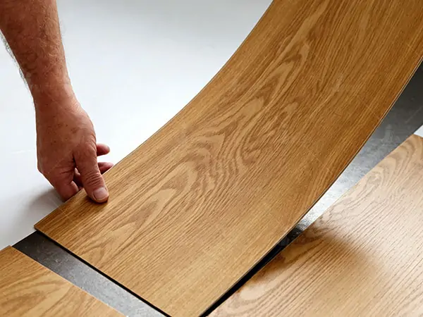 Installer fitting a wood-look flooring plank