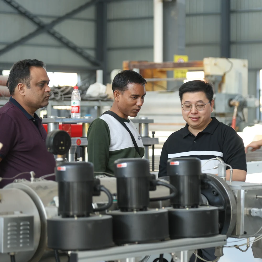 People inspecting extrusion equipment in a workshop
